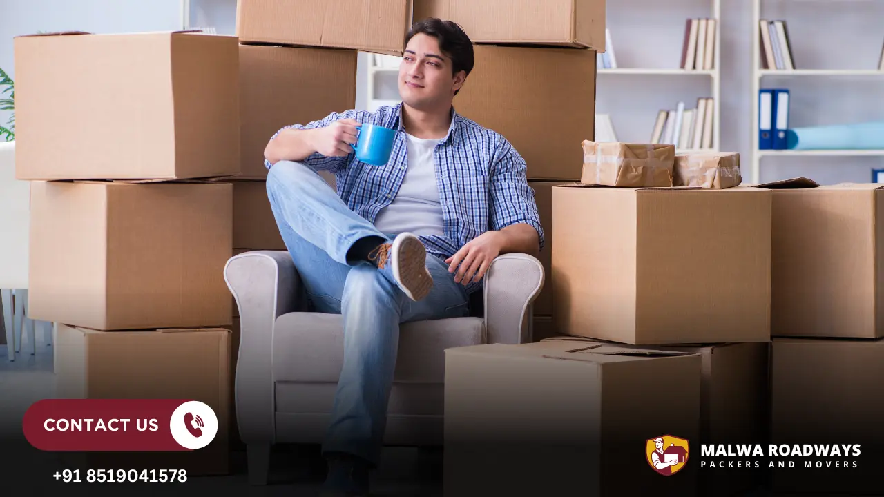 A Man sitting surrounded by moving boxes